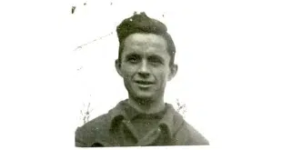 Photographie en noir et blanc de Herbert Matzel, extraite de sa carte de travailleur étranger. Il s'agit d'un jeune homme souriant, photographié en buste, portant une veste à col. Photo provenant des archives de la police allemande.