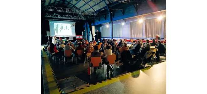 Soirée de solidarité avec la Palestine à la salle Latreille à Tulle – public assis devant une projection, organisée par l'AFPS 19.