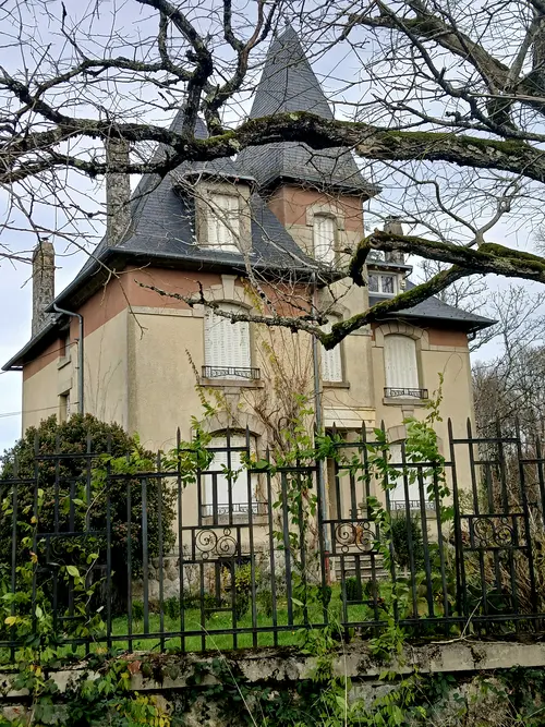 Maison ancienne à tour d'ardoise et volets blancs, refuge de la Résistance à Saint-Martin-la-Méanne. 