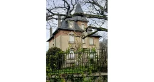Maison ancienne à tour et toit d'ardoise, volets blancs fermés, derrière une grille en fer forgé envahie de lierre. Lieu de mémoire de la Résistance et refuge de familles juives à Saint-Martin-la-Méanne.