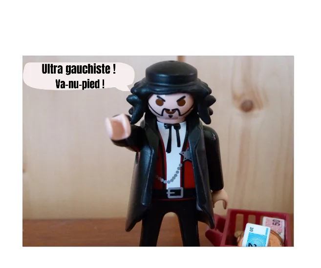 Photographie d'une figurine tenant une pancarte « ultra gauchiste ! t'as vu ma gueule ! »