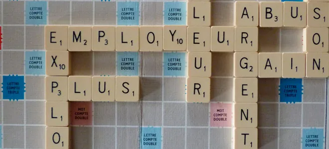 Photographie de lettres de Scrabble composant des mots sur un mur