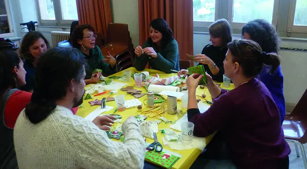 Photo : un atelier créatif autour d’une grande table à la P’tite Fabrique Solidaire