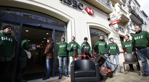 Photo : des militants de Bizi devant l’agence HSBC, mobilier saisi sur le trottoir