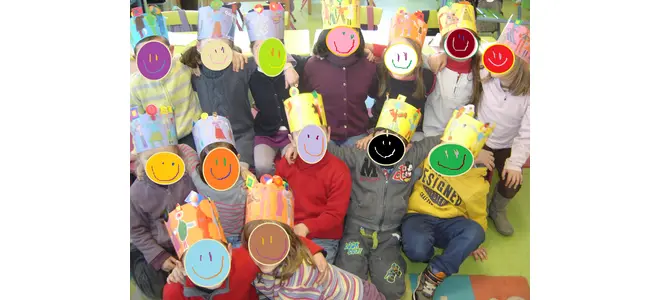 Photo : des enfants tiennent devant leur visage des masques ronds et colorés