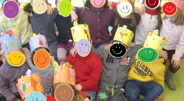 Photo : des enfants tiennent devant leur visage des masques ronds et colorés