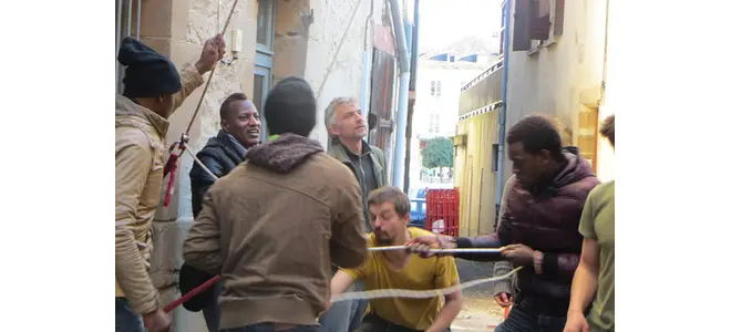 Photo : des jeunes et des habitants installent du mobilier dans une rue, à Beaulieu-sur-Dordogne
