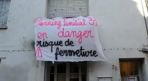 Photo : banderole « Planning familial 31 en danger » sur une façade à Toulouse
