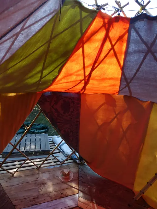 Photo : intérieur d’une yourte, parois colorées et plancher