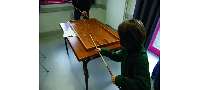Photo : un enfant joue à un jeu en bois à la ludothèque