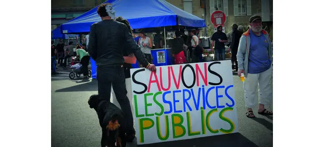 Photographie d’une manifestation à Guéret : une personne porte une pancarte « Sauvons les services publics ».
