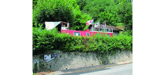 Photographie de la péniche rouge Gadabout amarrée à Mulatet, vue depuis la route.