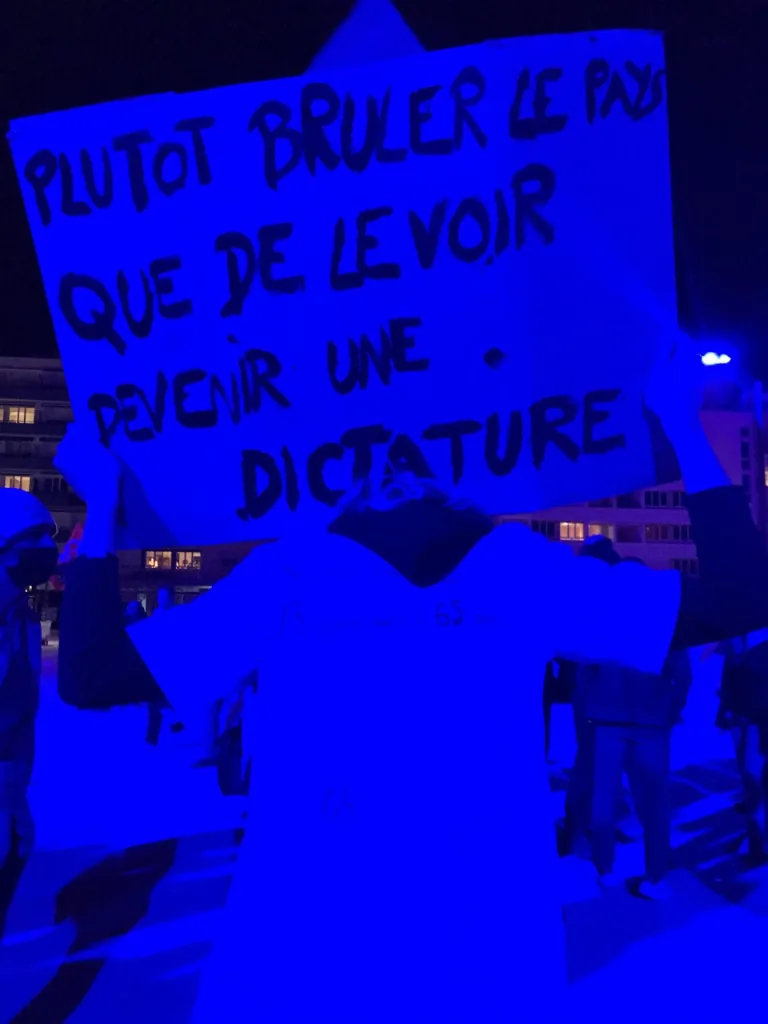 Photographie d'une banderole bleue dénonçant une « dictature »